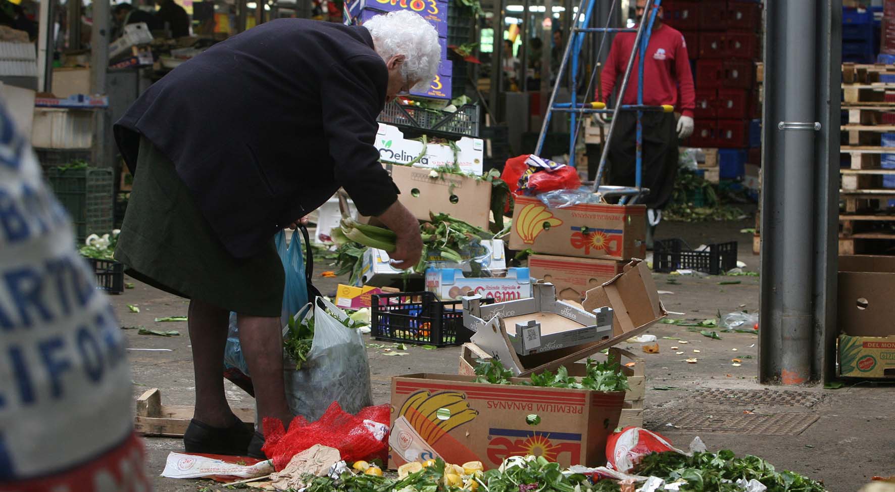 povertà anziana raccoglie scarti ortaggi mercato